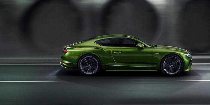  Bentley Cyprus Bentley Continental GT coupe in Tourmaline Green paint driving in profile on a dark road