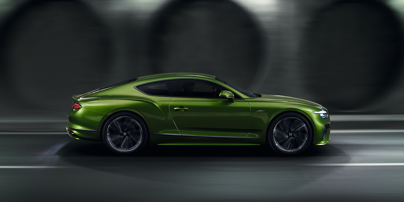 Bentley Cyprus Bentley Continental GT coupe in Tourmaline Green paint driving in profile on a dark road